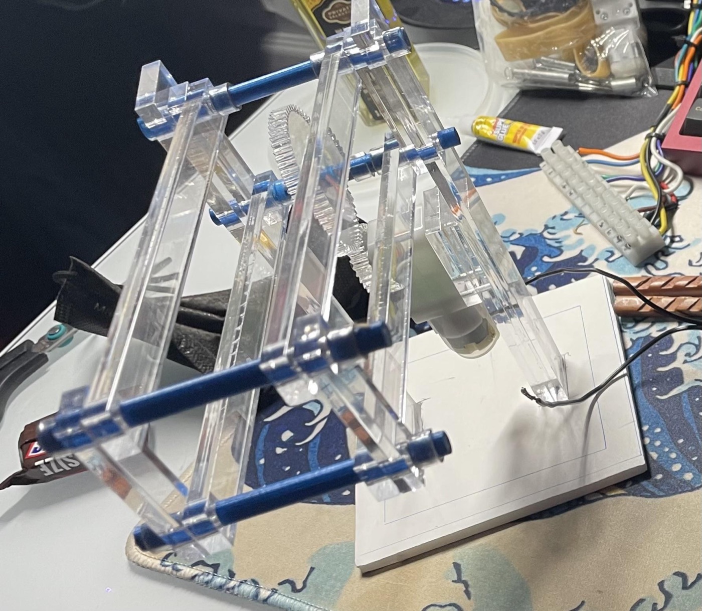 An early four-bar lift prototype in clear acrylic with 12-pitch gears and a small motor